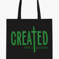 Black tote bag with green text 'CREATED with a purpose' on a white background