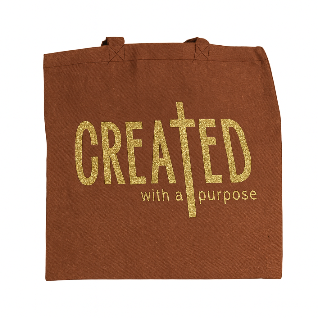 Brown tote bag with 'CREATED with a purpose' text in gold on a white background