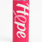 Pink tumbler with 'Hope' written on it against a white background
