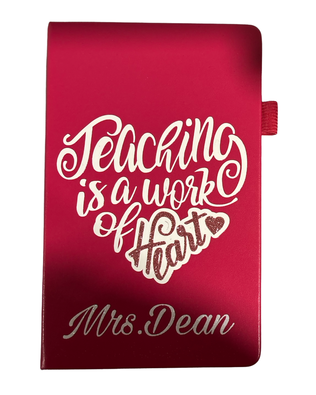 Red notebook with 'Teaching is a work of heart' and 'Mrs. Dean' text on a white background